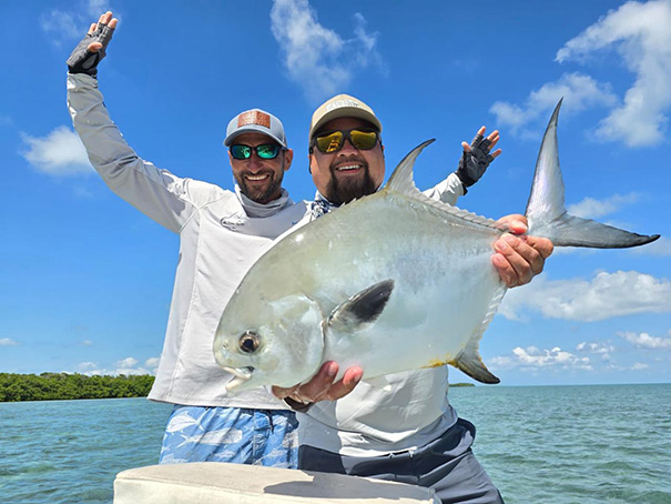 fly-fishing-placencia-belize-2-men-with-a-fish-605x454